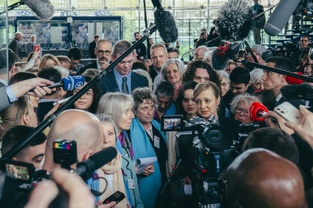 Two swiss activist being surrounded by journalists