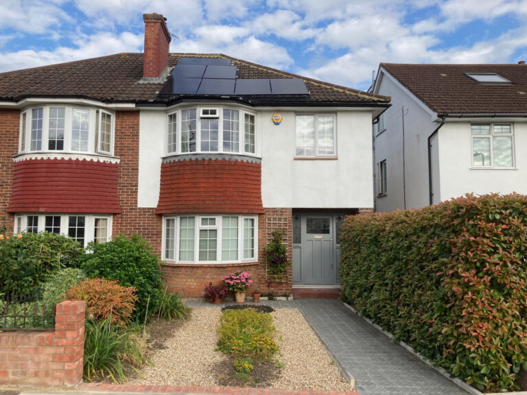 A semi-detatched house with a small front garden and a paved path