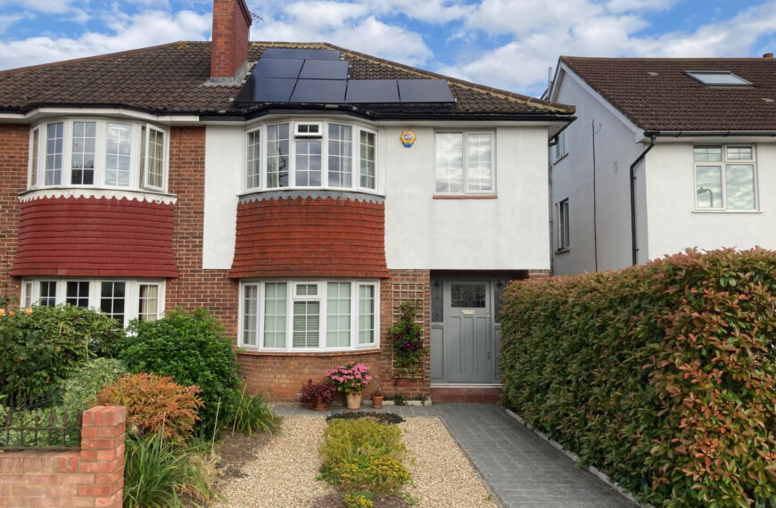 A semi-detatched house with a small front garden and a paved path
