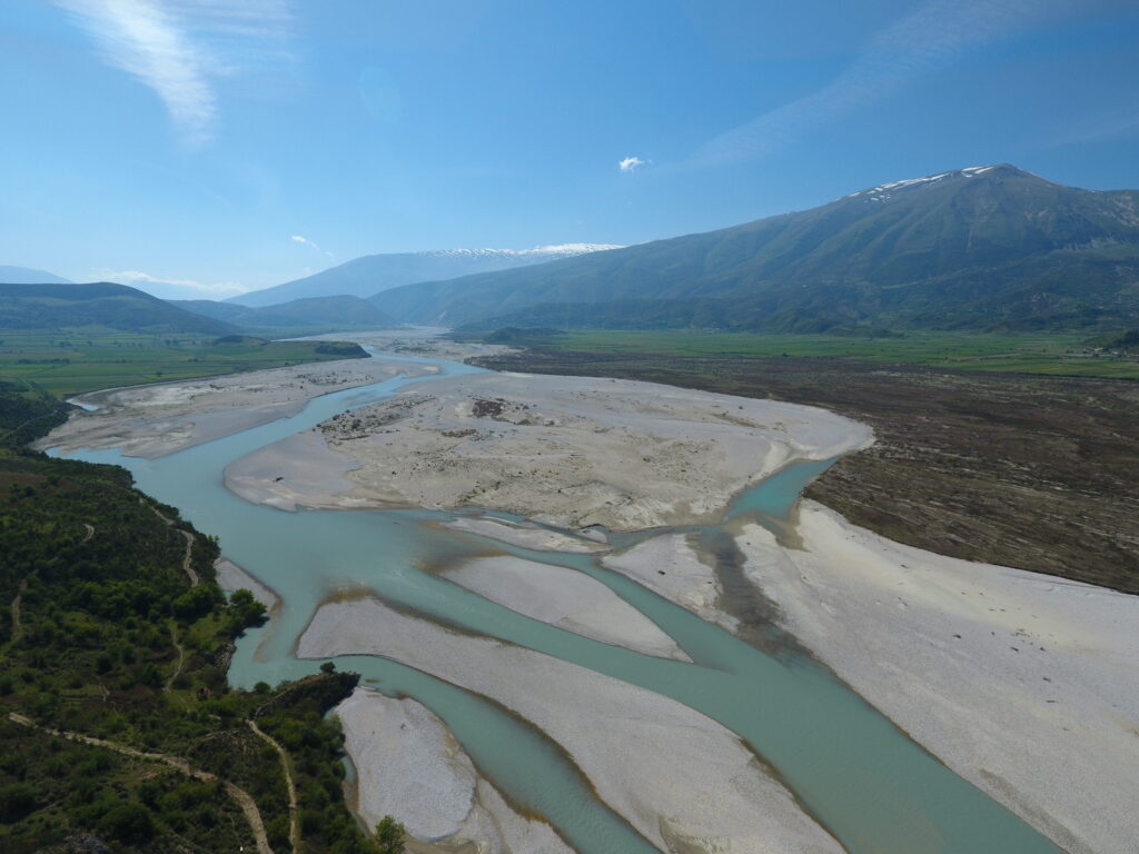 A river, with hills on the background, sunny day and a vivid blue sky.