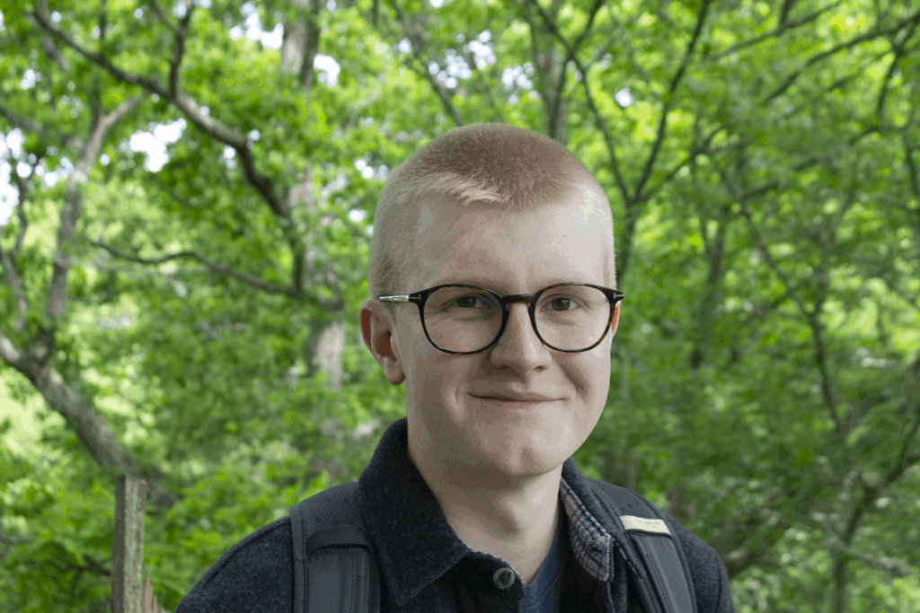 Ned Win standing in woodlands on the Knepp Estate