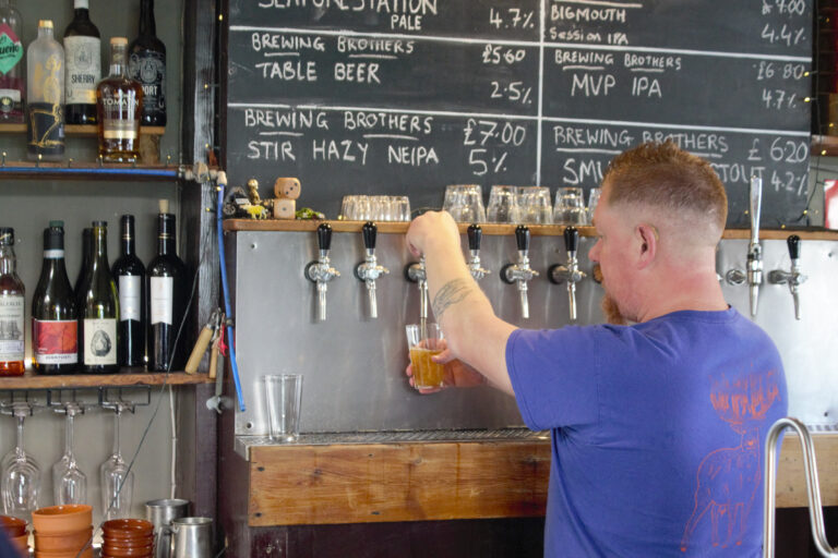 A bartender pulls a pint of the Seaforestation kelp pale ale at The Brewing Brothers