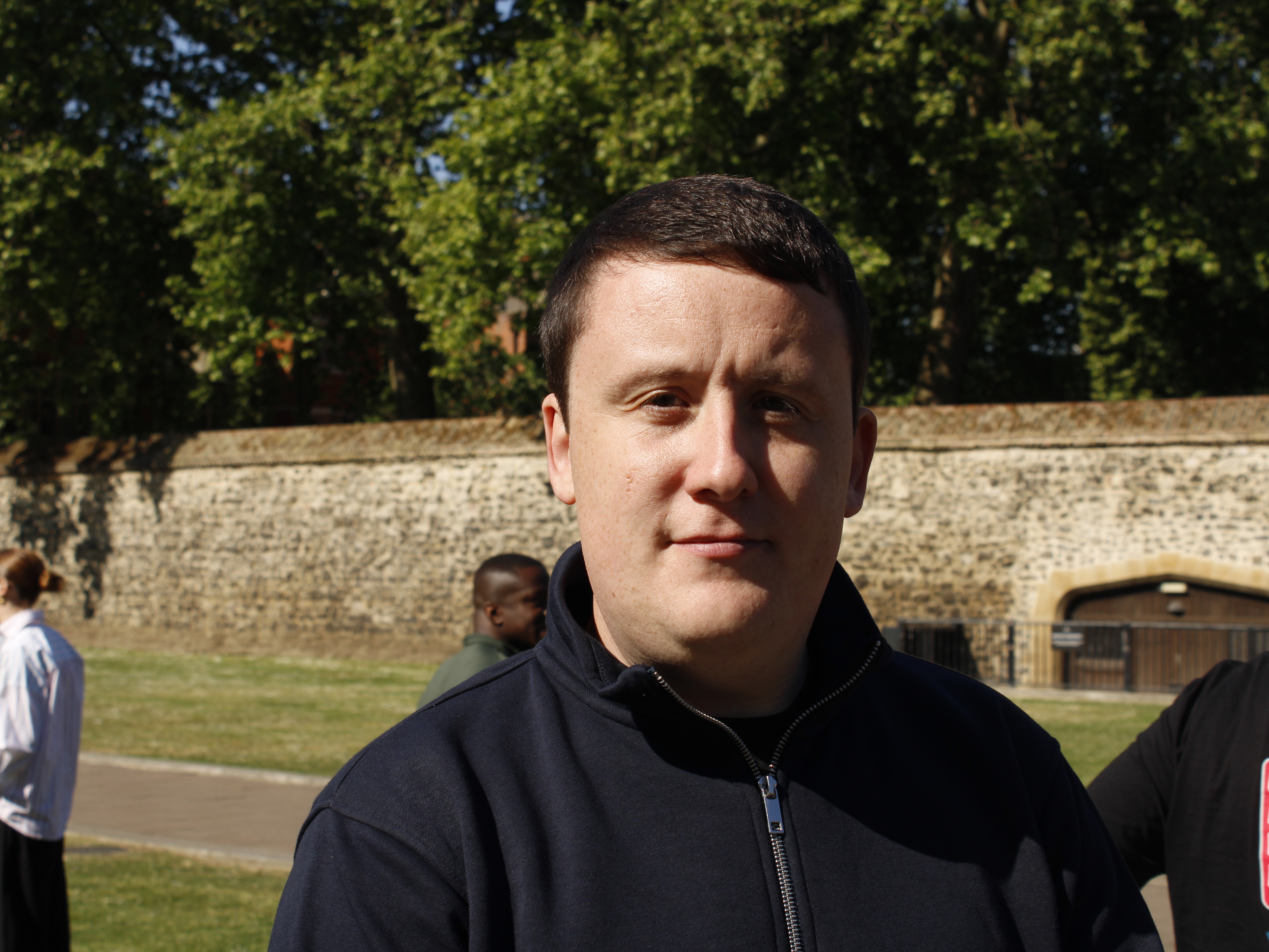 A man in a dark zip-up fleece faces the camera