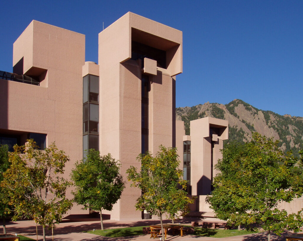 A modernist building, with hills and sky in the background