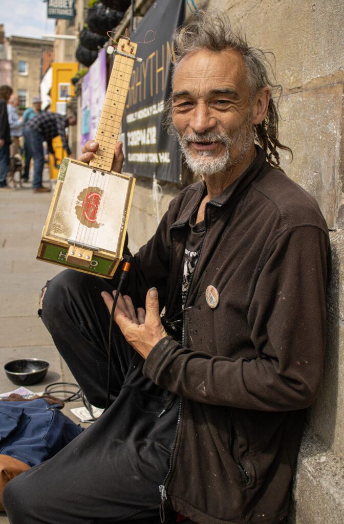 Man holds up a homemade ukulele