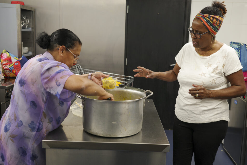 Two members of the Chagossian community in Crawley prepare lunch.