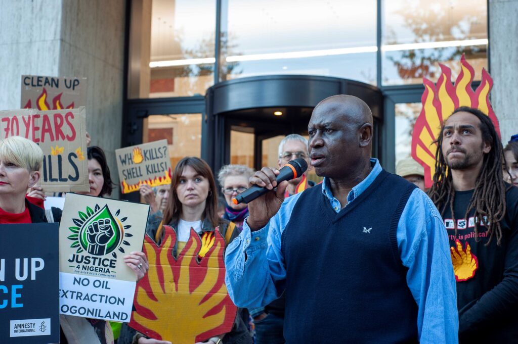A man speaks into a Microphone outside Shell Headquarters